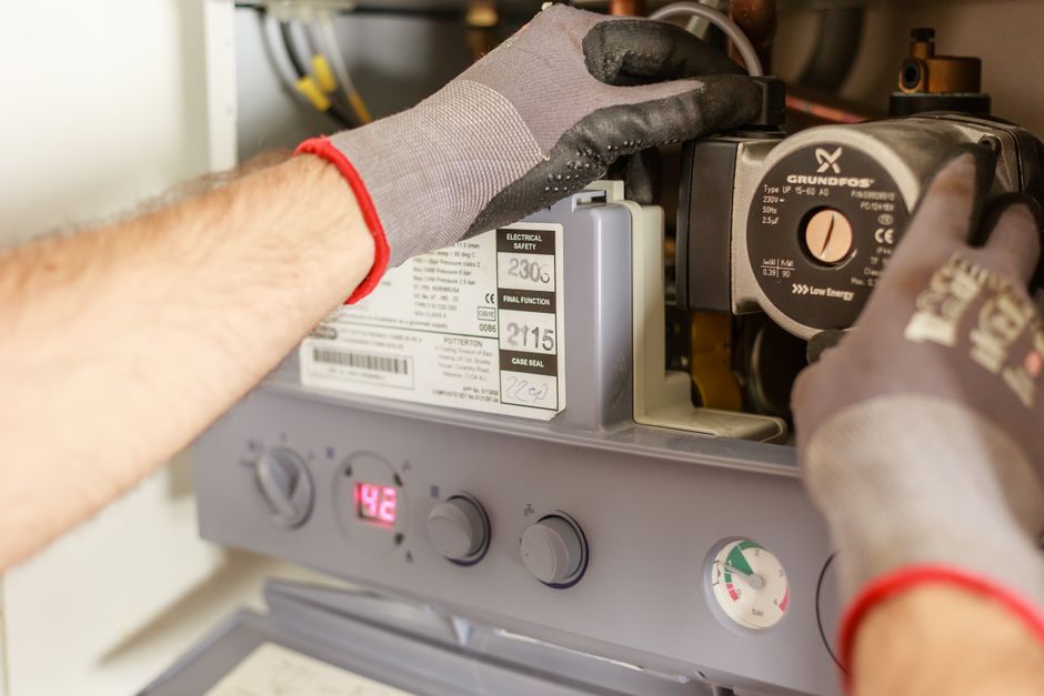 Technicien qui inspecte une pompe de circulation Grundfos avant intervention SAV