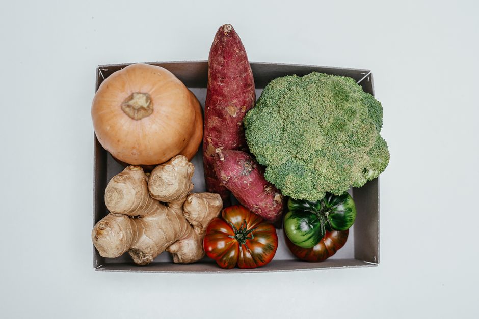 Ingrédients frais pré-dosés d'une box repas posés sur un plan de travail avec une fiche recette