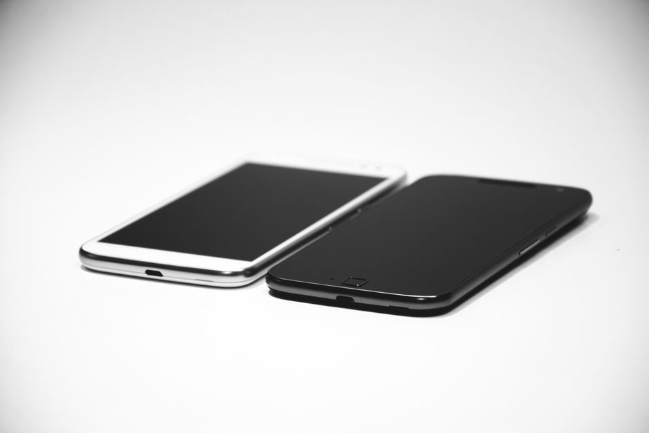 Technicien testant un smartphone reconditionné sur un plan de travail d'atelier
