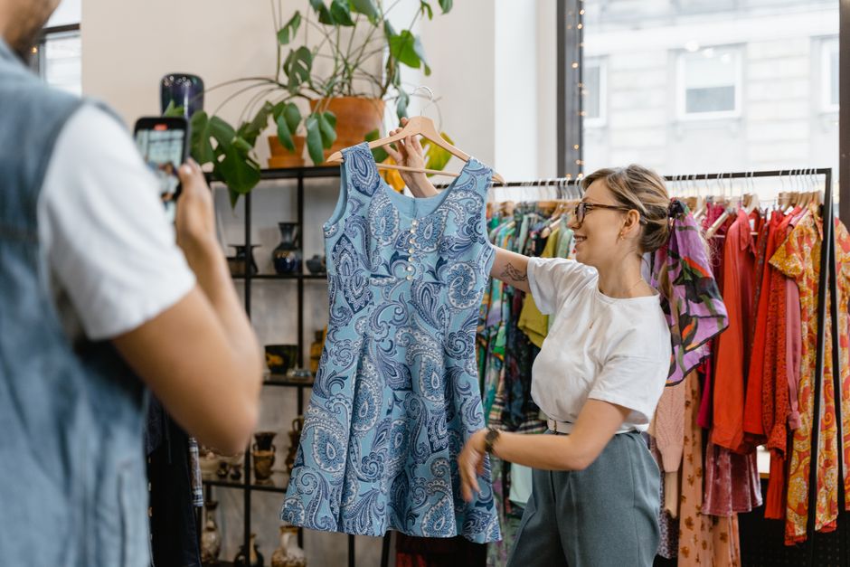 Vendeuse préparant des colis de vêtements de seconde main pour expédition
