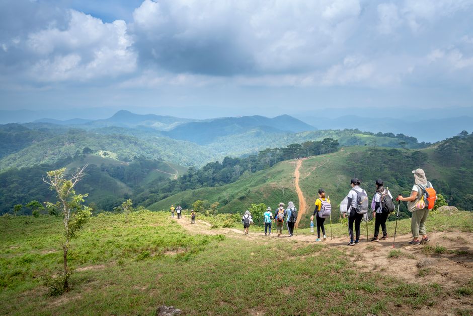 Groupe de voyageurs en randonnée avec sacs à dos, façon voyage d'aventure en groupe