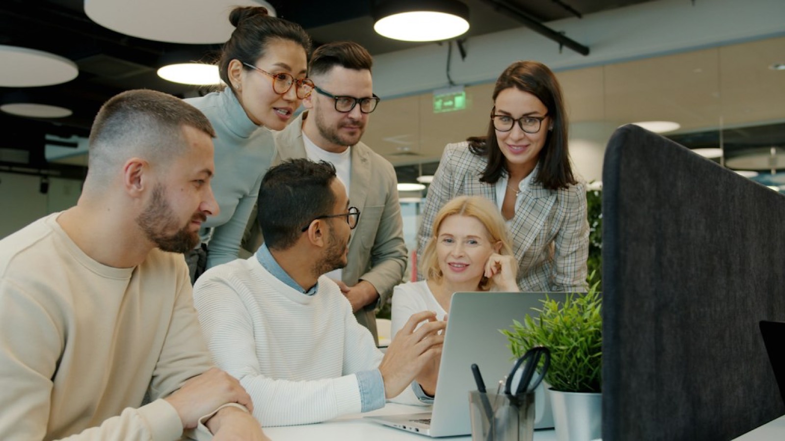 Équipe collaborant devant un écran de tableau de bord lors d'une réunion