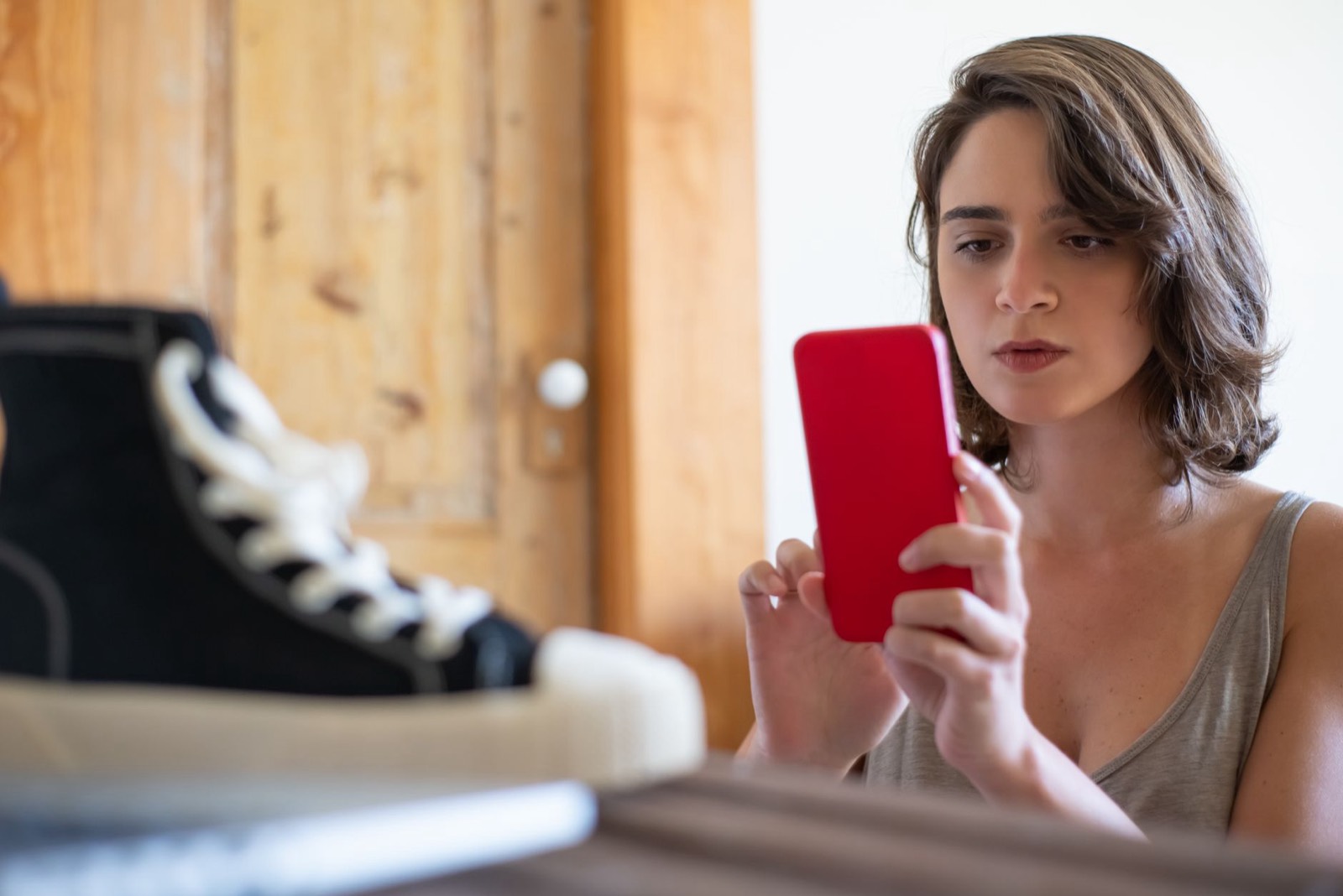 Baskets, veste et smartphone posés pour préparer une annonce de vêtements d'occasion